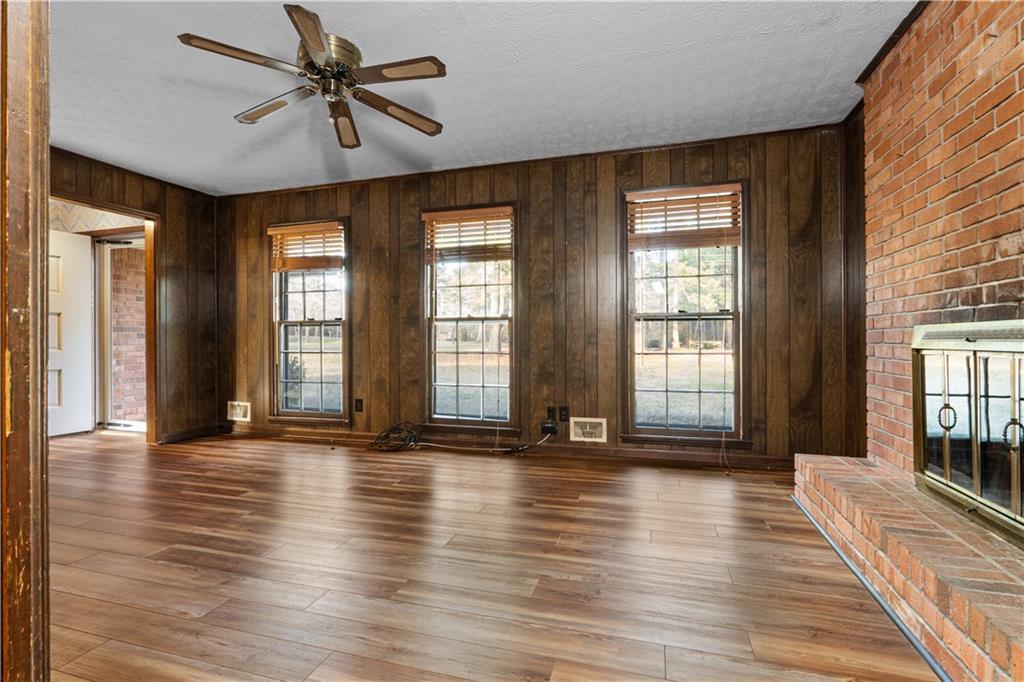7085 Hobgood Road Fairburn, GA 30213 - Photo 4 of 40 a view of an empty room with a window and wooden floor