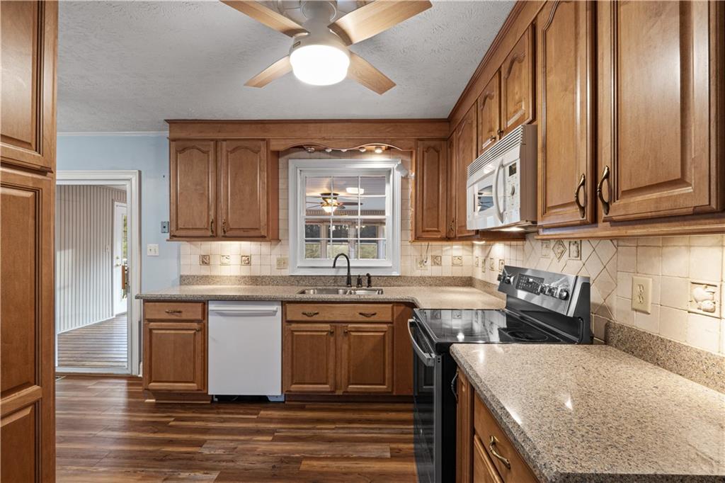7085 Hobgood Road Fairburn, GA 30213 - Photo 6 of 40 a kitchen with stainless steel appliances granite countertop a sink a stove and cabinets