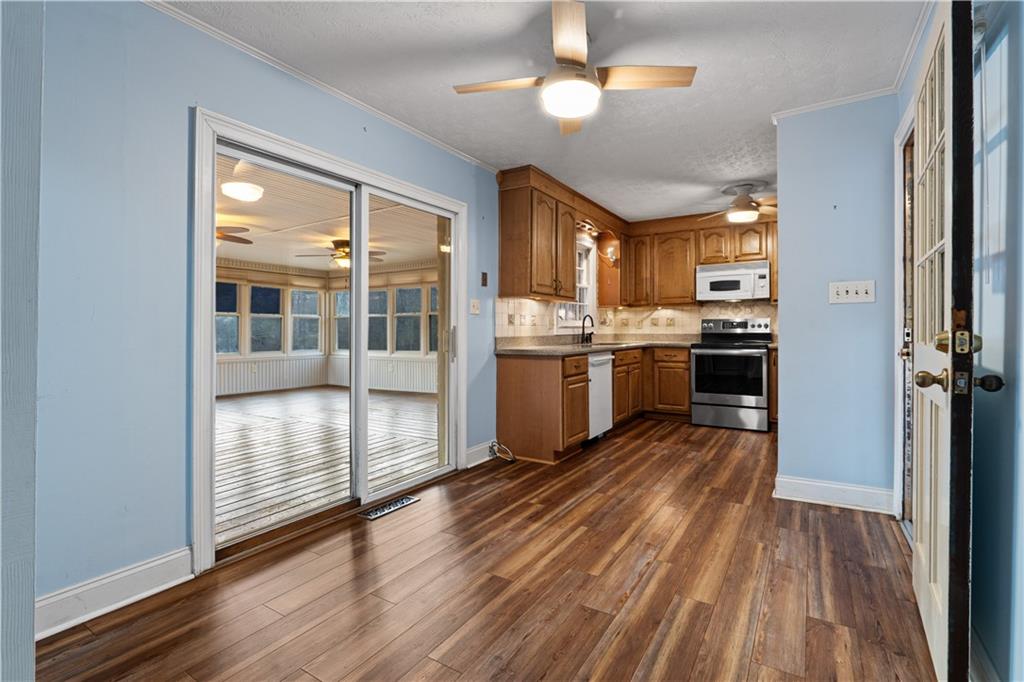 7085 Hobgood Road Fairburn, GA 30213 - Photo 8 of 40 a large kitchen with cabinets wooden floor and stainless steel appliances