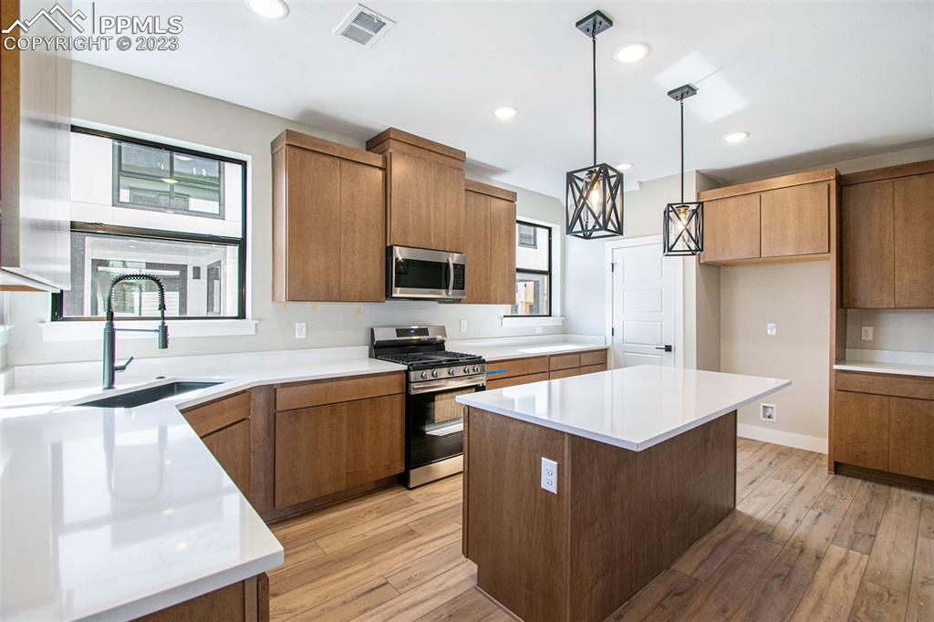 1968 Peridot Loop Heights Colorado Springs, CO 80908 - Photo 2 of 10 a kitchen with stainless steel appliances granite countertop a sink a stove and a refrigerator