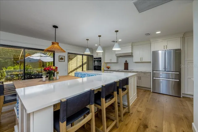 a kitchen with stainless steel appliances granite countertop a kitchen island a stove and a refrigerator