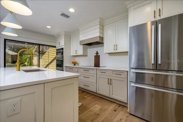 a kitchen with white cabinets and stainless steel appliances