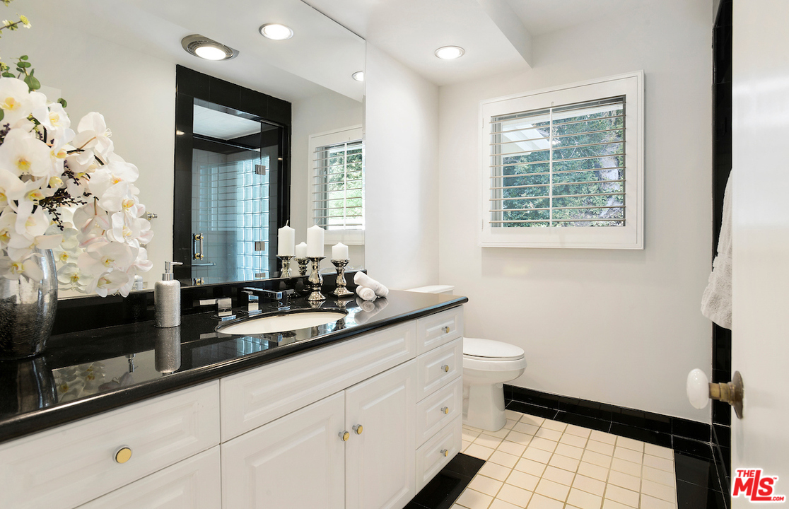 1124 Laurel Way Beverly Hills, CA 90210 - Photo 19 of 31 a bathroom with a sink a toilet and a mirror