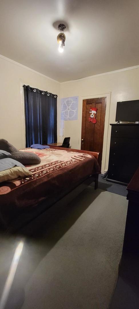 10652 South Ave B Chicago, IL 60617 - Photo 11 of 18 a bedroom with a bed and a television