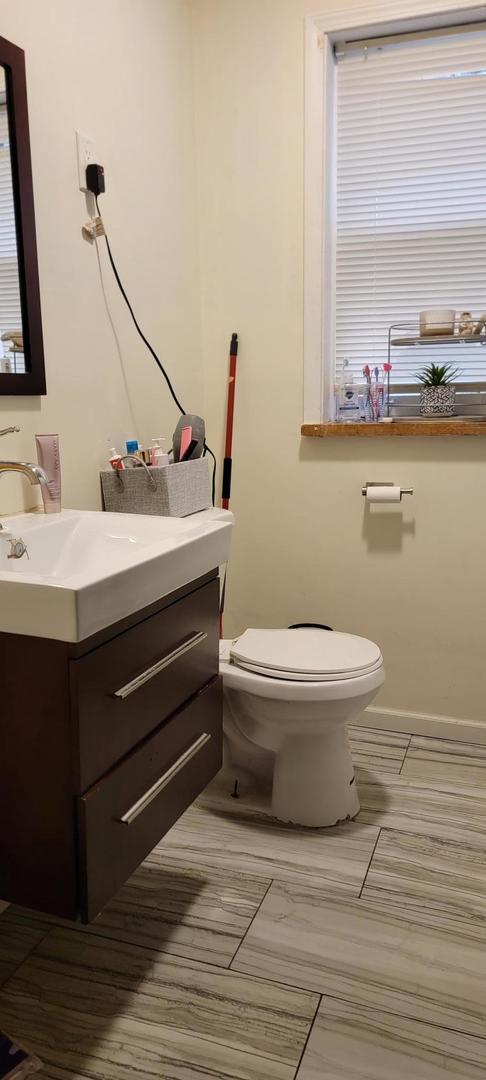 10652 South Ave B Chicago, IL 60617 - Photo 14 of 18 a bathroom with a sink a toilet and mirror