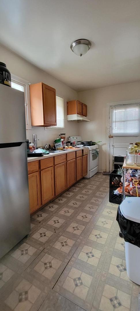 10652 South Ave B Chicago, IL 60617 - Photo 10 of 18 a kitchen with stainless steel appliances granite countertop a sink stove and refrigerator