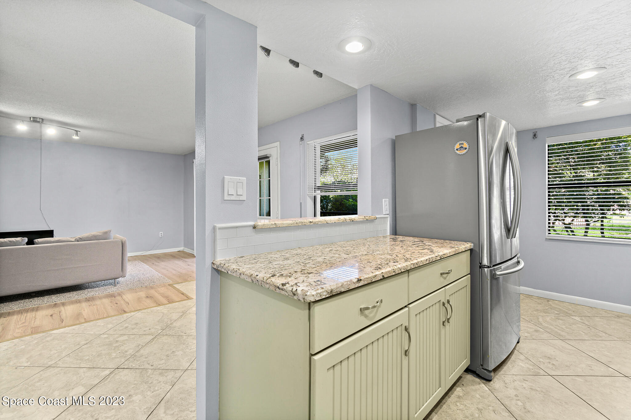 500 Catalina Road, Unit 103 Cocoa Beach, FL 32931 - Photo 10 of 28 a kitchen with stainless steel appliances granite countertop a sink stove and refrigerator
