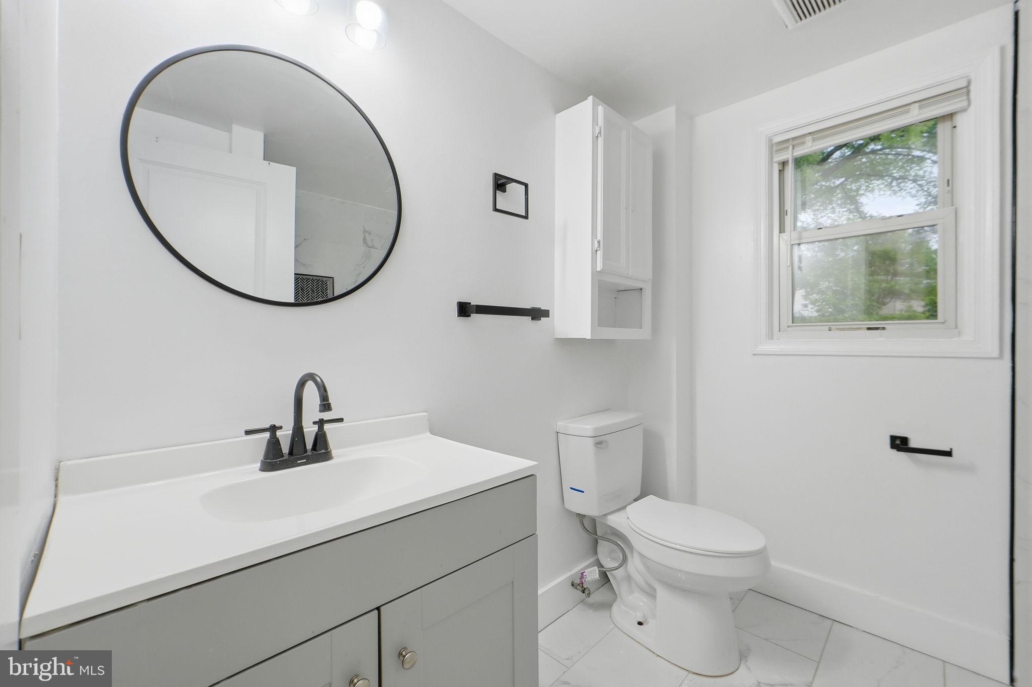 5906 Berwyn Road College Park, MD 20740 - Photo 20 of 46 a bathroom with a toilet a sink and a mirror
