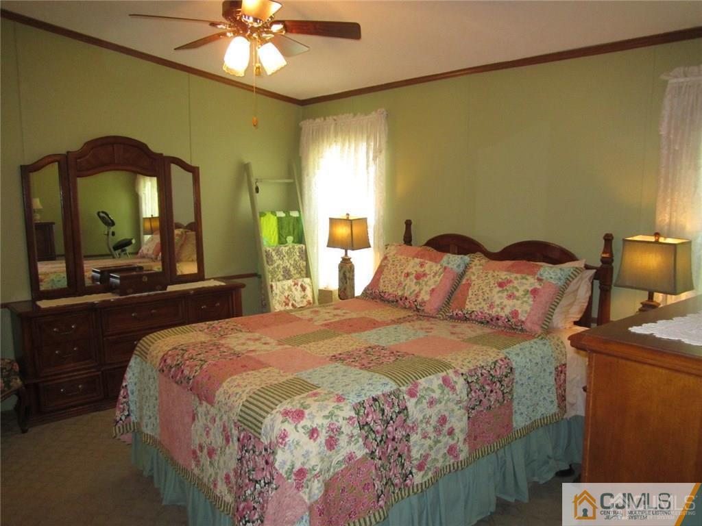 25 Longfellow Road, Unit 1 North Brunswick, NJ 08902 - Photo 11 of 17 a bedroom with a bed and a chandelier