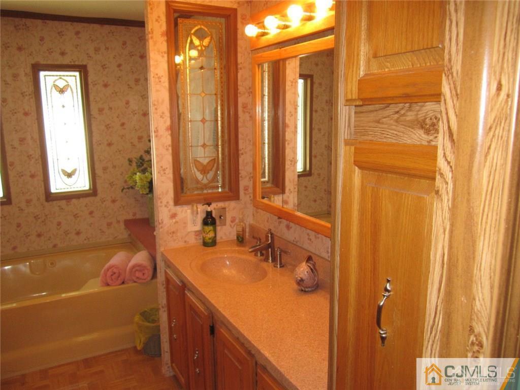 25 Longfellow Road, Unit 1 North Brunswick, NJ 08902 - Photo 13 of 17 a bathroom with a sink a mirror and a shower