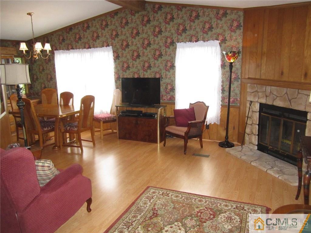 25 Longfellow Road, Unit 1 North Brunswick, NJ 08902 - Photo 2 of 17 a living room with furniture a fireplace and a flat screen tv