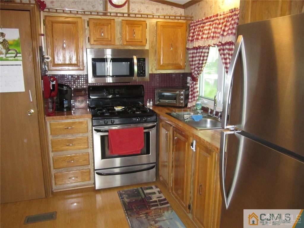 25 Longfellow Road, Unit 1 North Brunswick, NJ 08902 - Photo 8 of 17 a kitchen with stainless steel appliances a stove and a refrigerator