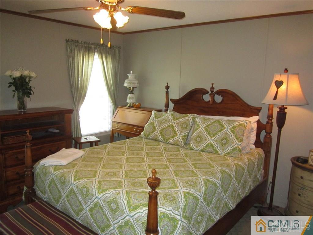 25 Longfellow Road, Unit 1 North Brunswick, NJ 08902 - Photo 9 of 17 a bedroom with a bed and a chandelier