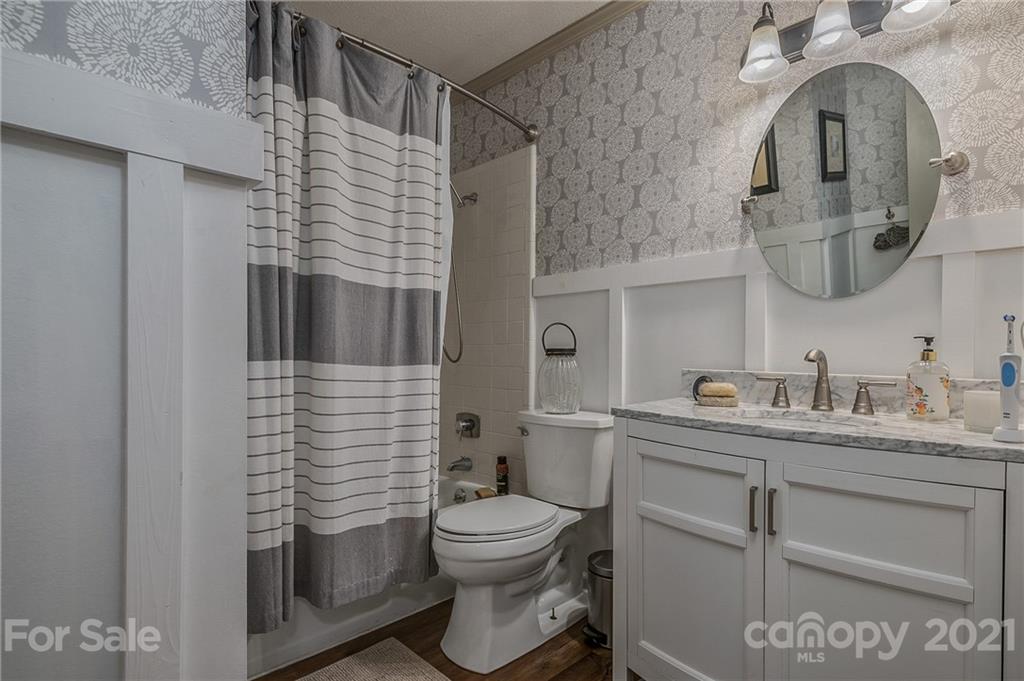 137 Anne Street Rutherfordton, NC 28139 - Photo 11 of 45 a bathroom with a granite countertop toilet sink and mirror