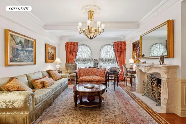 a living room with furniture a chandelier and a fireplace