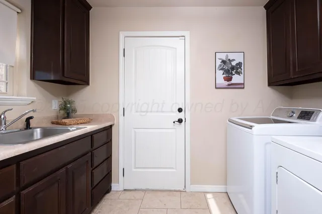 a utility room with cabinets washer and dryer