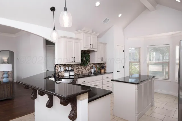 a kitchen with kitchen island granite countertop a sink stainless steel appliances and cabinets