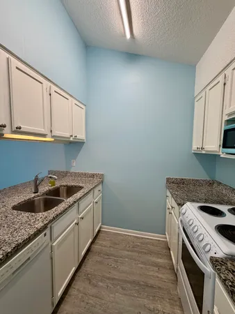 a kitchen with granite countertop a sink and a stove