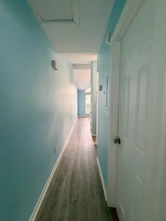 a view of a hallway with wooden floor