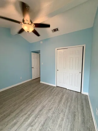 a view of an empty room with wooden floor