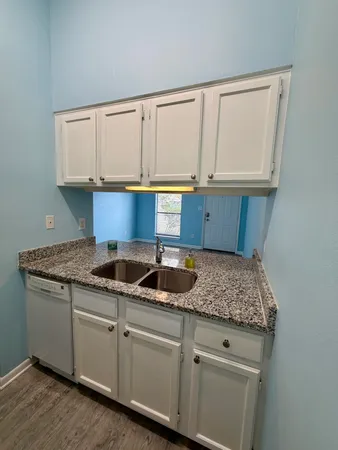 a kitchen with granite countertop a sink and cabinets