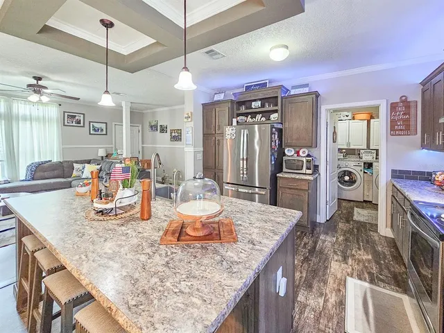 a kitchen island with granite countertop a table and chairs in it