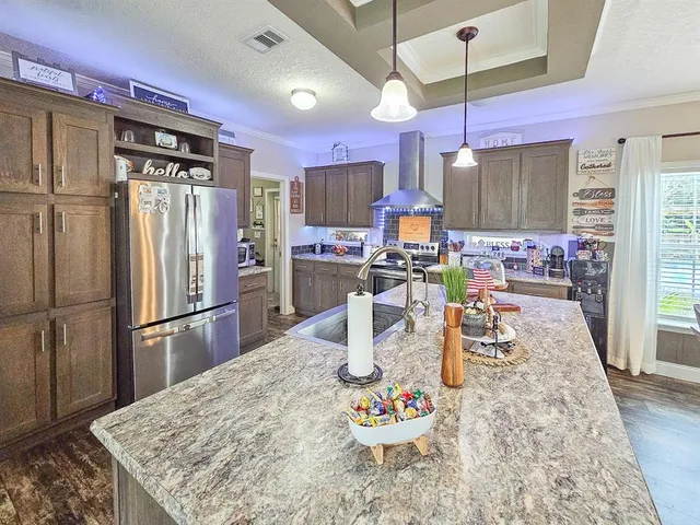 a kitchen with stainless steel appliances kitchen island granite countertop a refrigerator a stove a oven with white countertops and chairs