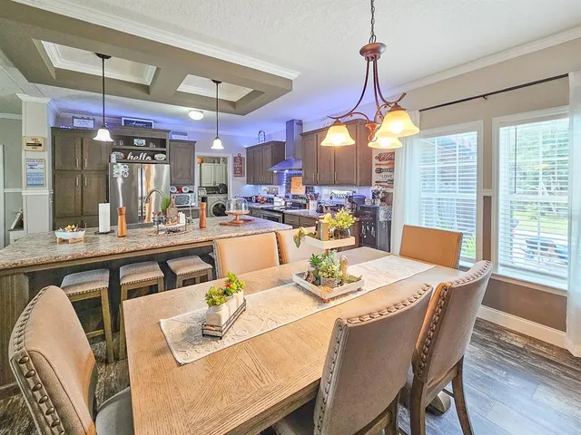 a dining room with furniture a chandelier and wooden floor