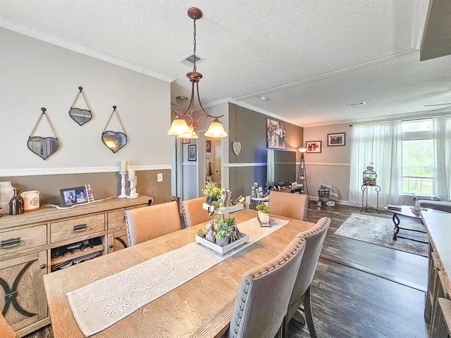 a living room with furniture kitchen view and large windows