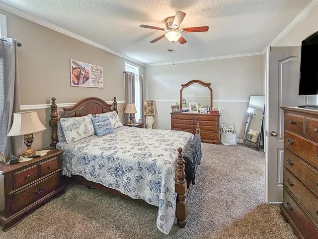 a spacious bedroom with a bed and a flat screen tv