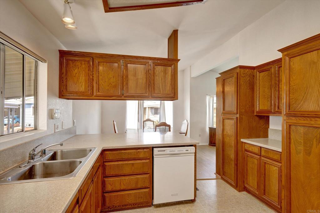 205 Mockingbird Lane Oceanside, CA 92057 - Photo 11 of 28 a kitchen with stainless steel appliances granite countertop a sink a refrigerator and cabinets