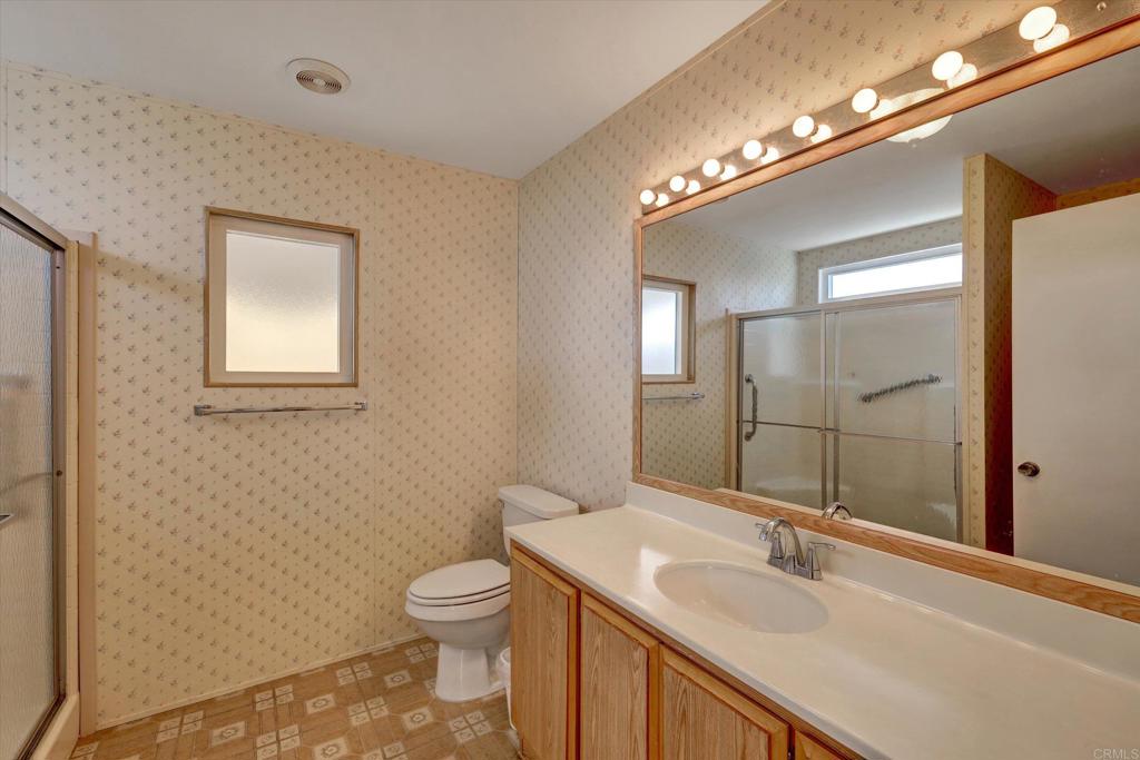 205 Mockingbird Lane Oceanside, CA 92057 - Photo 19 of 28 a bathroom with a toilet a sink and mirror