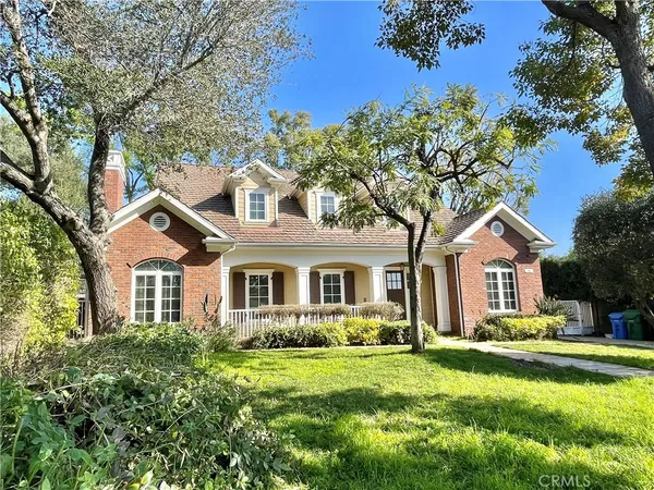 a front view of a house with a yard and trees