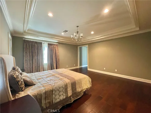 a spacious bedroom with a bed and a chandelier