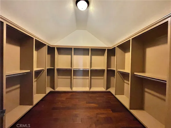 a view of an empty room with wooden floor and closet