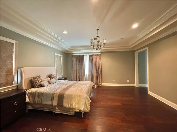 a bedroom with a large bed and a chandelier