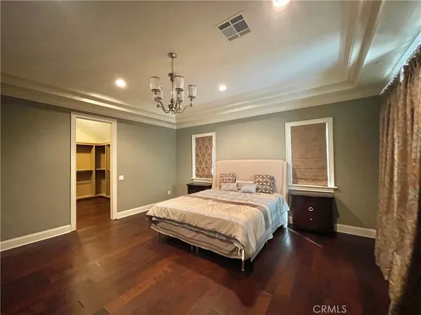 a bedroom with a large bed and wooden floor