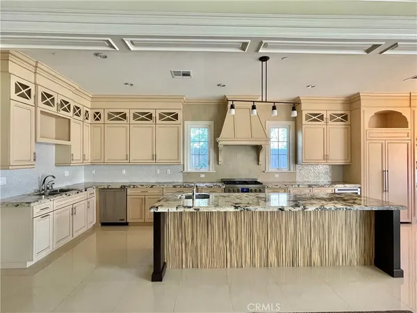 a kitchen with granite countertop a sink a stove and cabinets