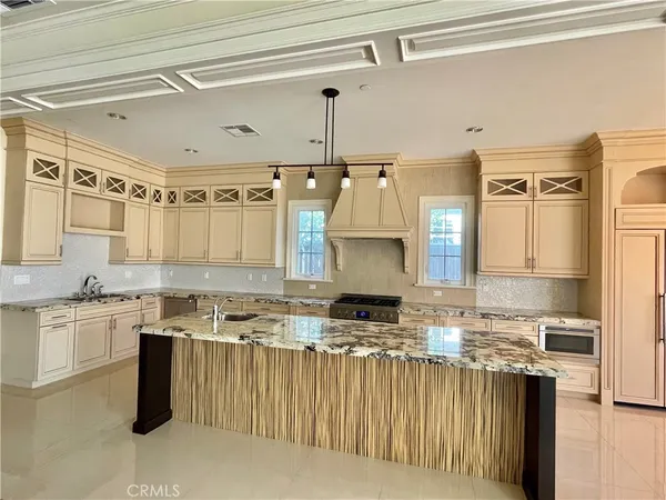 a kitchen that has a lot of cabinets in it and wooden floors