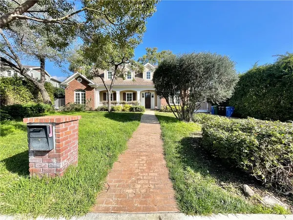 a front view of a house with a yard and potted plants