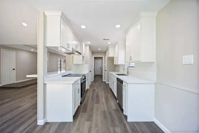 a kitchen with cabinets and wooden floors