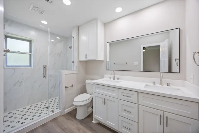 a spacious bathroom with a double vanity sink mirror and toilet
