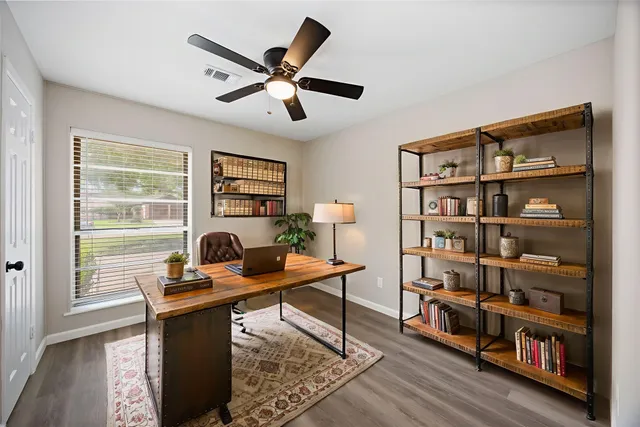 a view of a workspace with furniture and a window