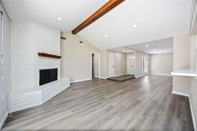 a view of a room with wooden floor and fireplace