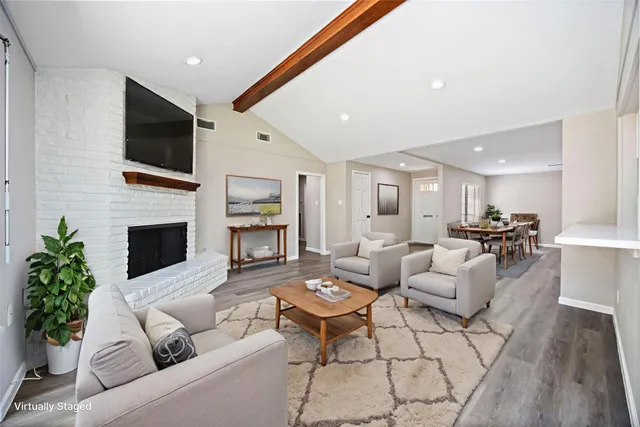 a living room with furniture a flat screen tv and a fireplace