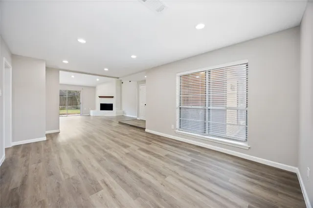 a view of empty room with wooden floor and windows