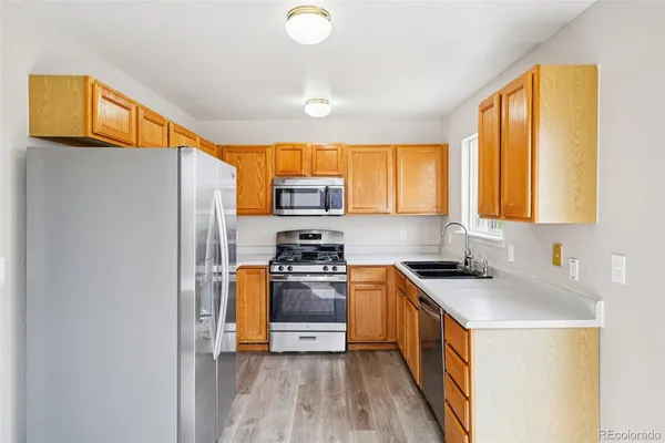 a kitchen with stainless steel appliances granite countertop a stove a sink a refrigerator and a microwave