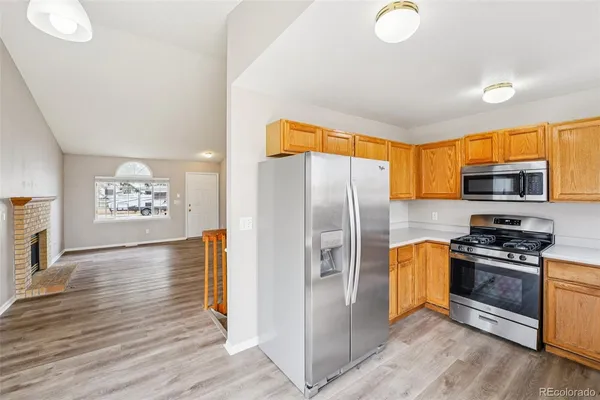 a kitchen with stainless steel appliances granite countertop a refrigerator a stove top oven a sink and dishwasher