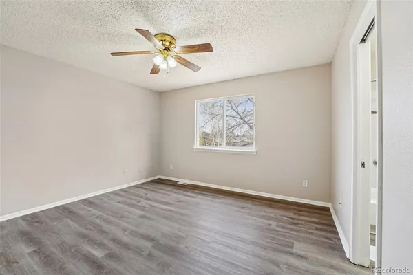 a view of an empty room with wooden floor