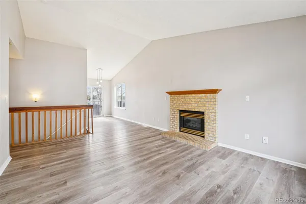 a view of empty room with wooden floor and fireplace